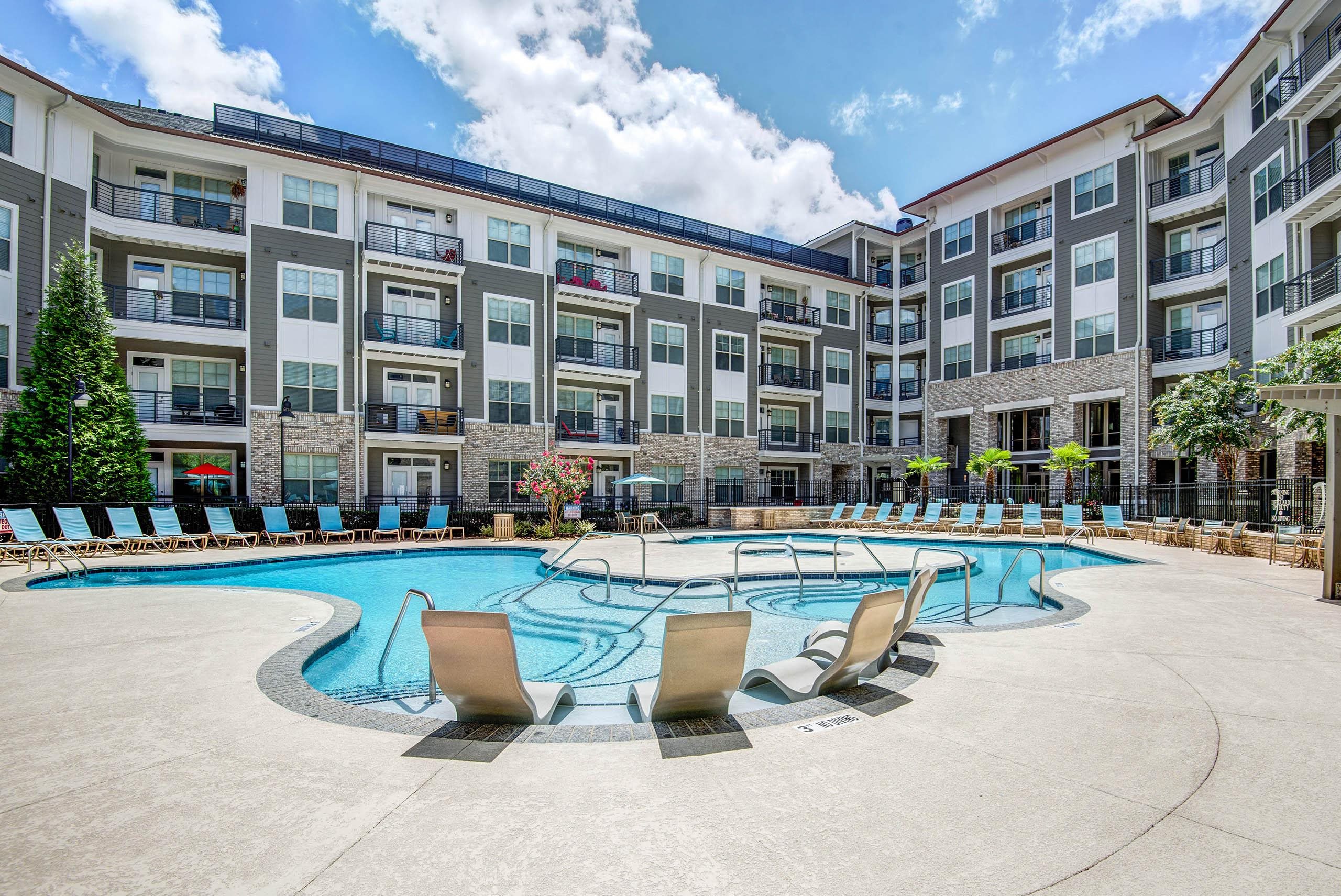a swimming pool with an apartment building in the background at The Tribute, North Carolina